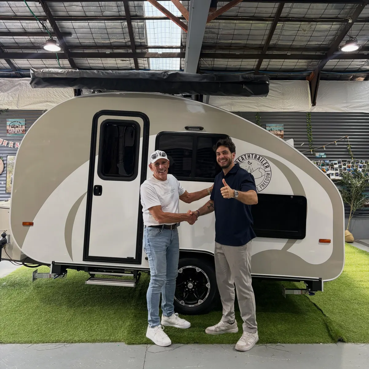 Andrew shaking hands with the Breath team beside his cream Max at collection