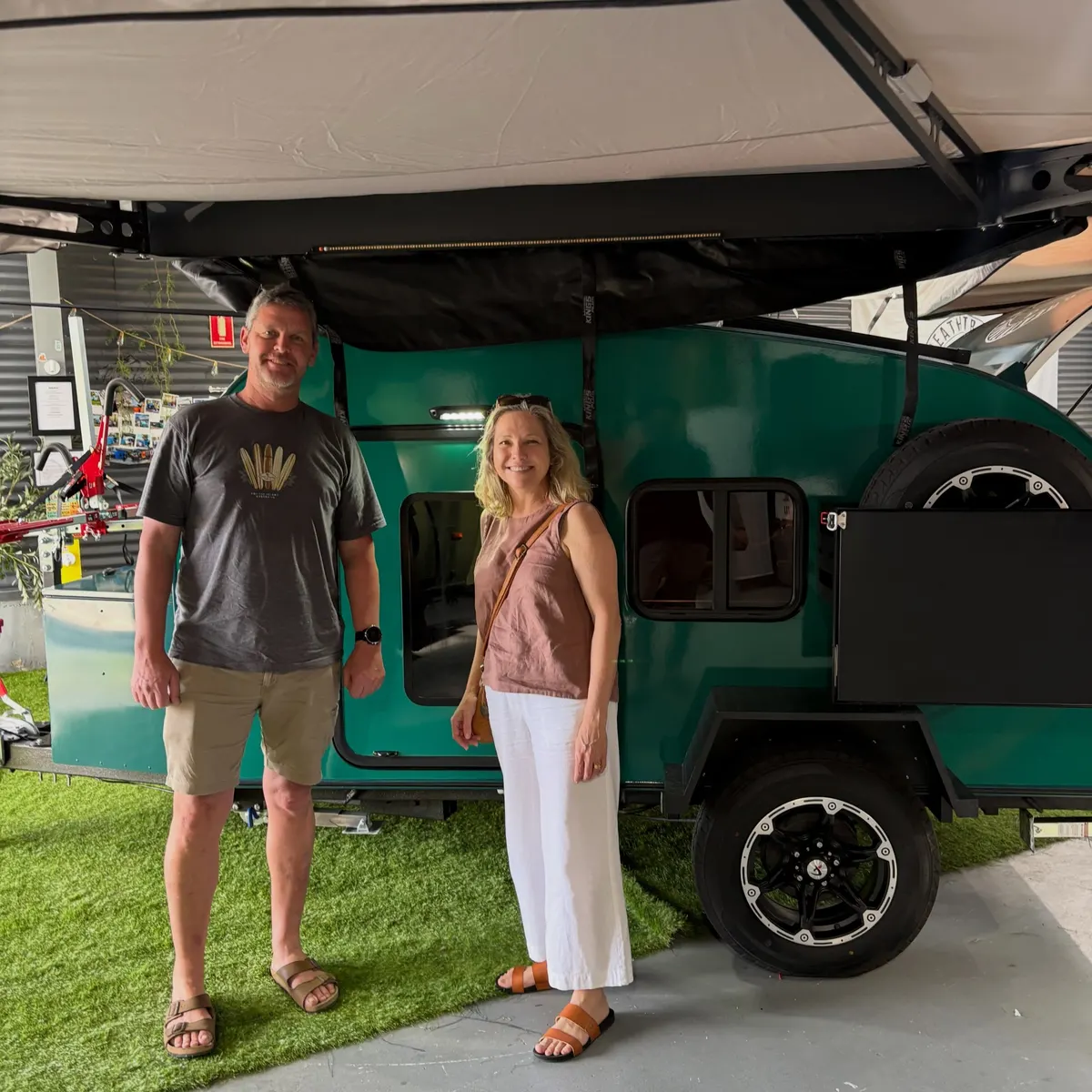 Belinda and Trent beside their green Breath Ultra under its open awning