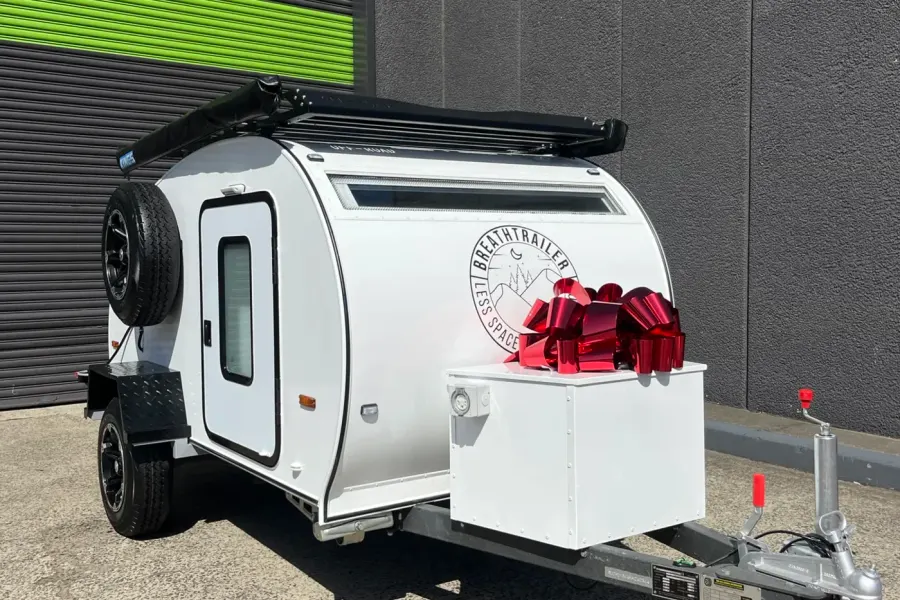 White compact Breath teardrop with a big red gift bow on the front toolbox