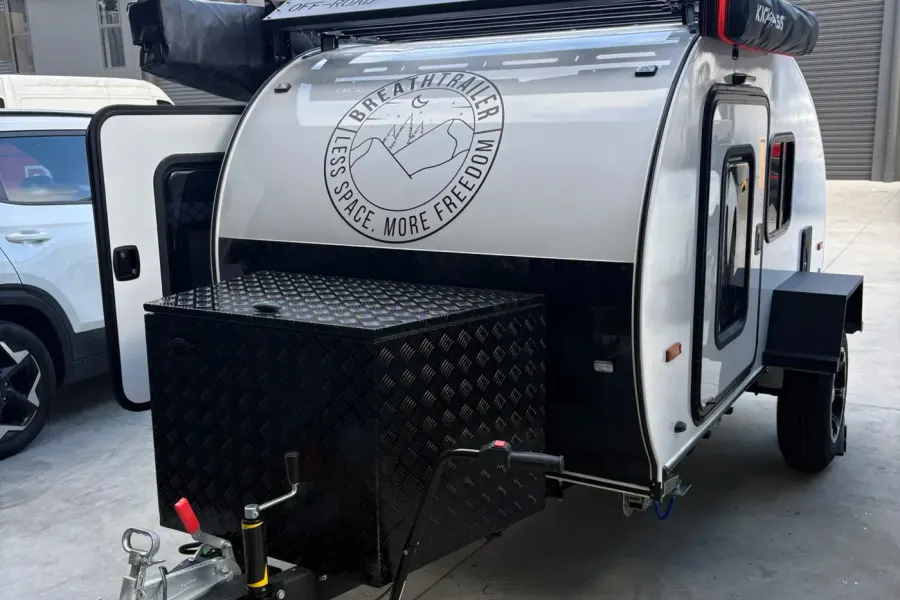 Silver compact Breath teardrop front with black checker-plate toolbox and both side doors visible