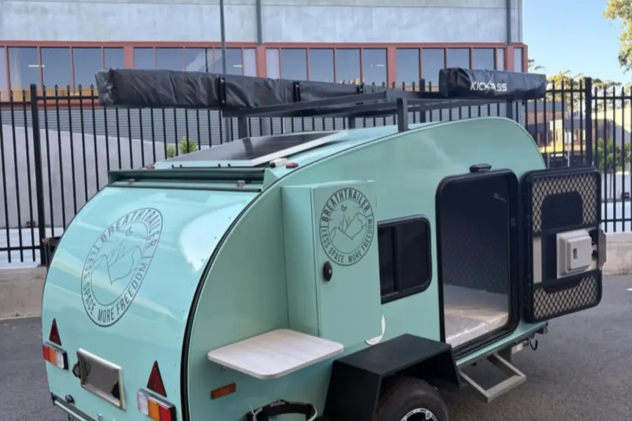 Breath Ultra in mint green with side door open, fold-out table, solar panel and roof rack