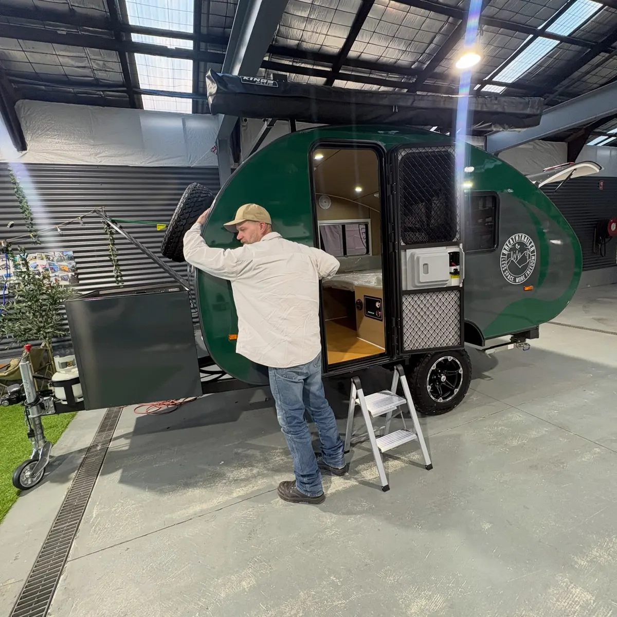 Dalius beside his green Max at collection with the entry door open