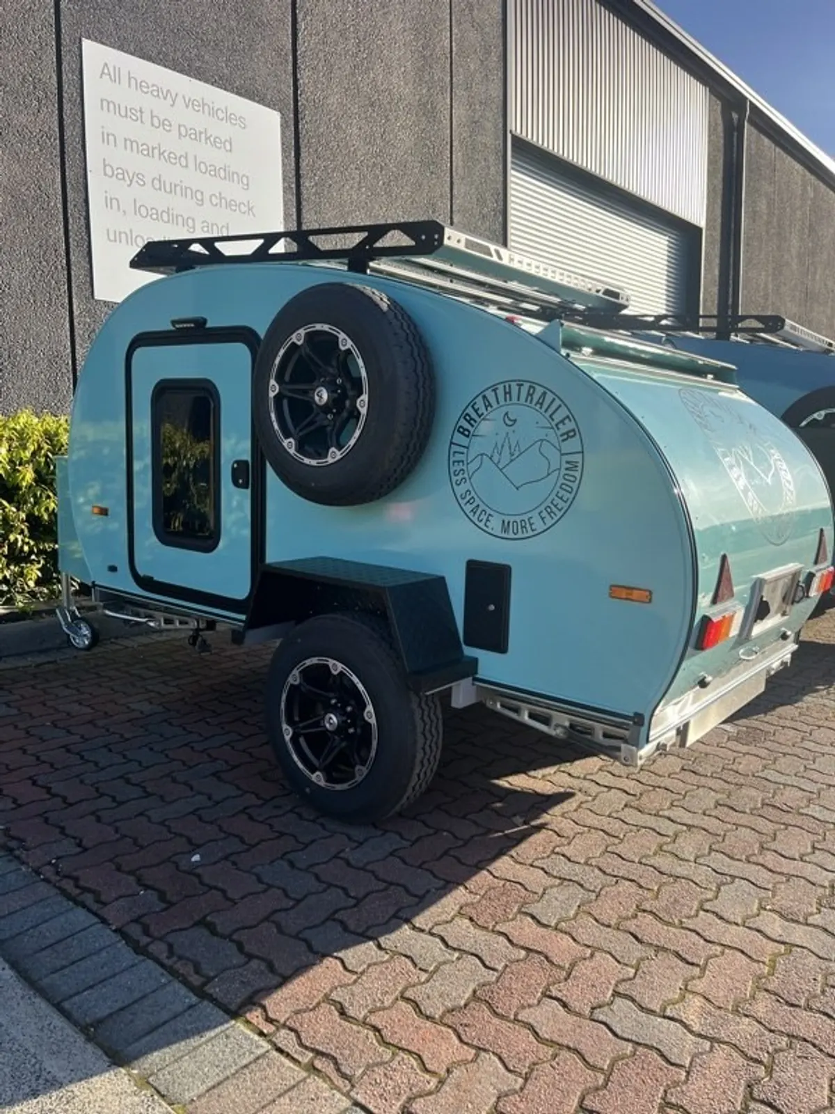 Pale blue Plus with front box and spare tyre at the workshop