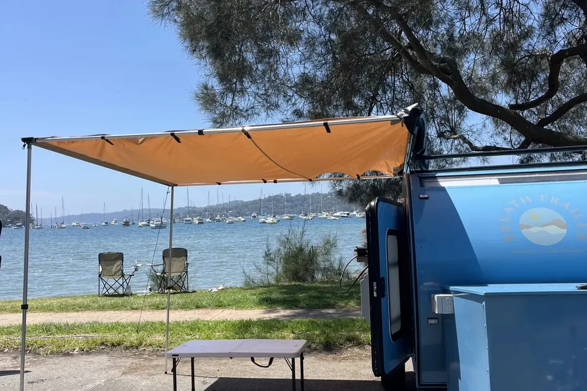 Blue Plus with awning open beside the water