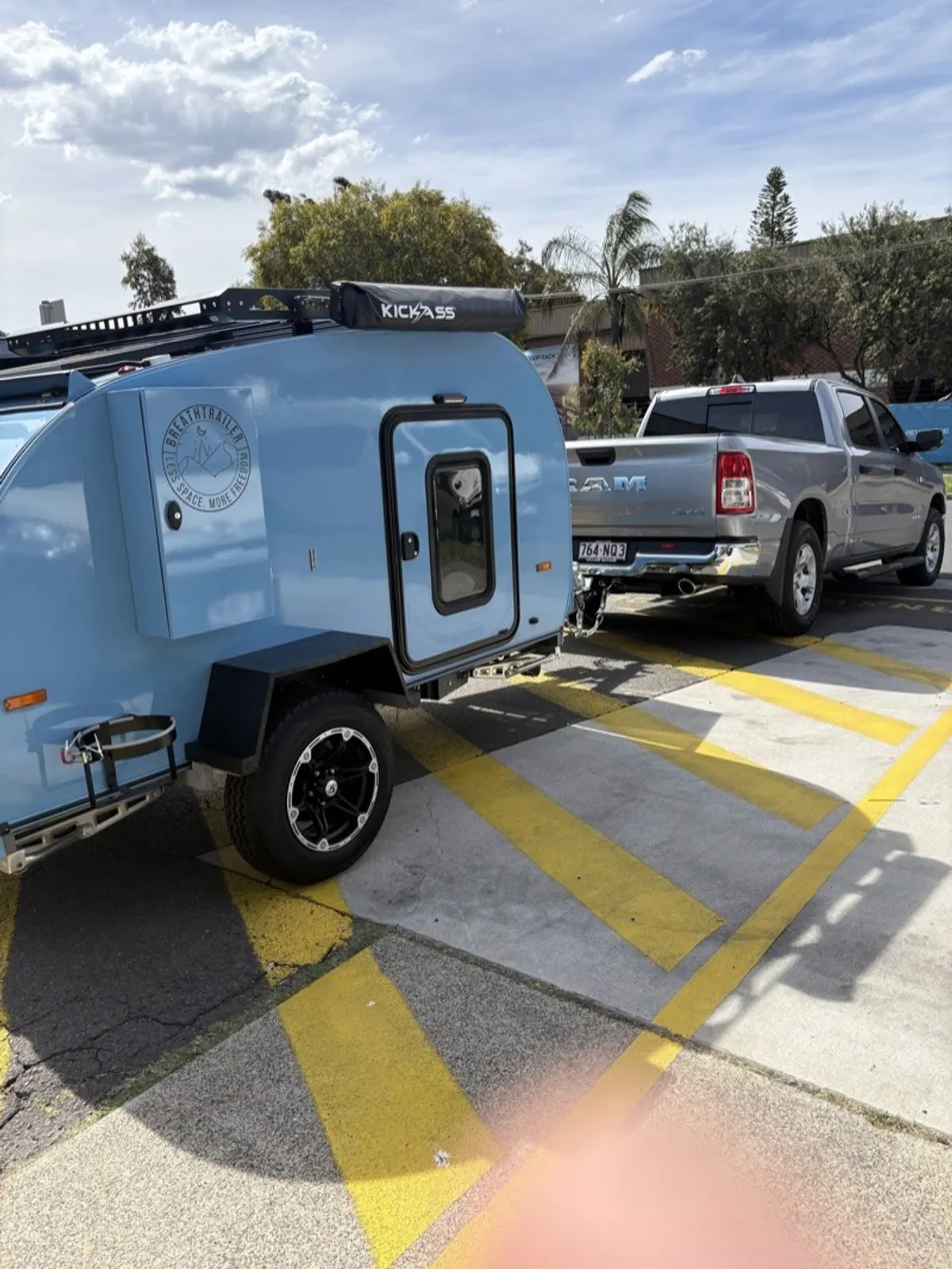 Blue Ultra hitched to a pickup outside the workshop