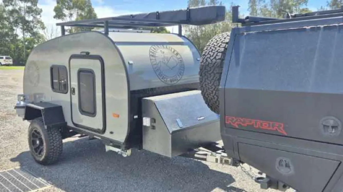Grey Ultra beside its tow vehicle on a trip