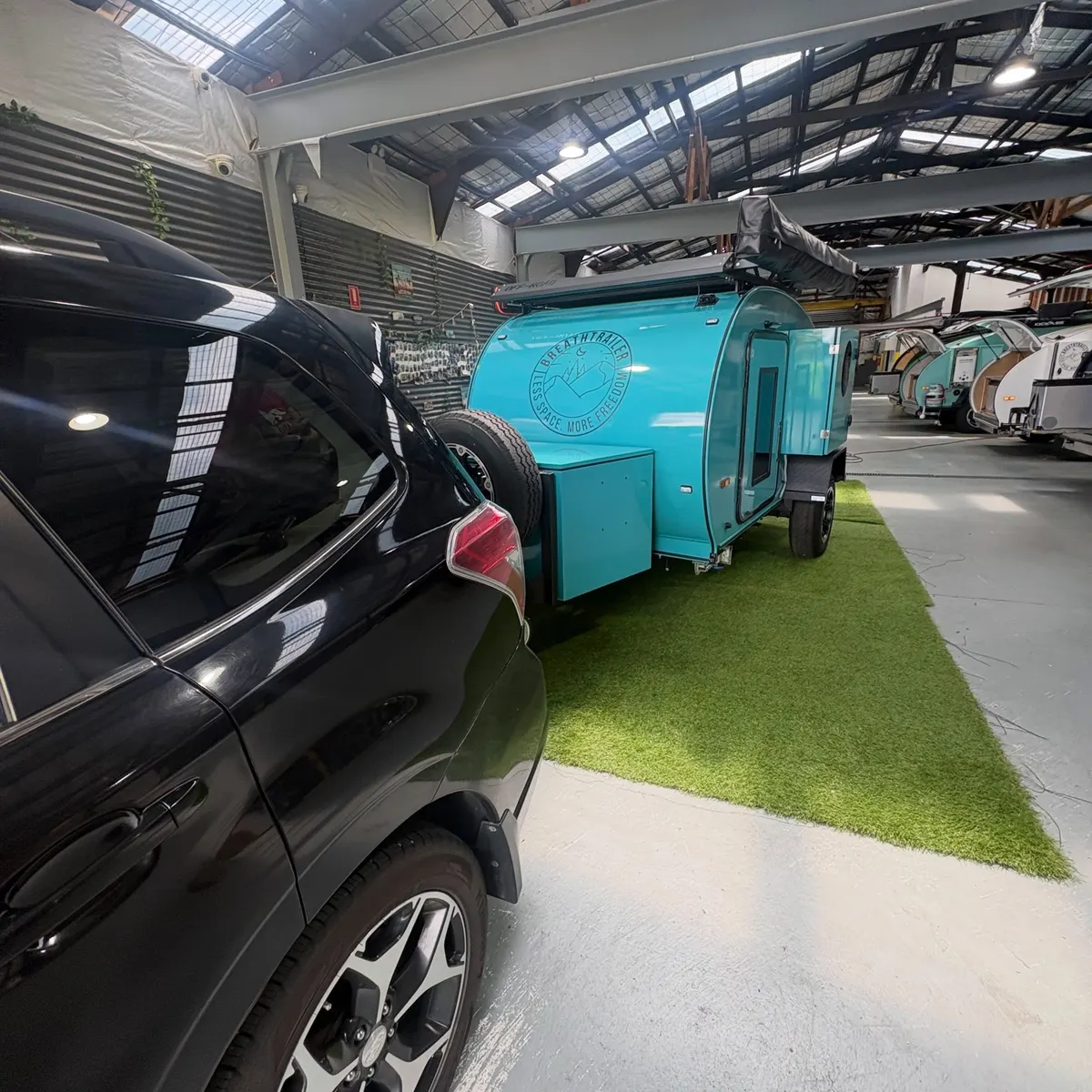 Nicole’s turquoise Plus coupled to a car inside the workshop