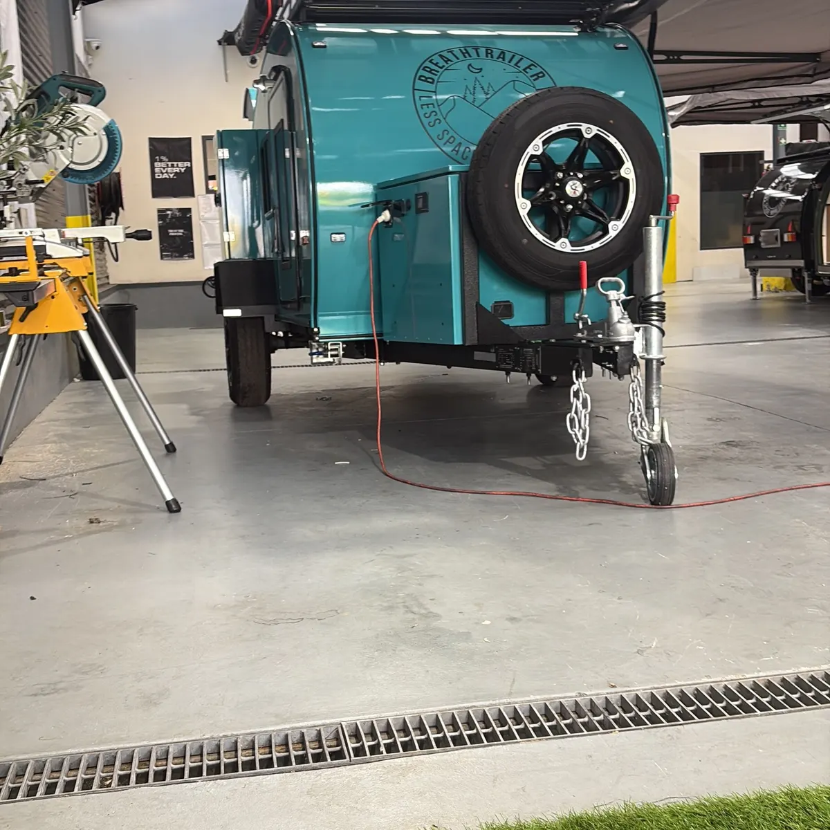 Front view of turquoise Plus with spare tyre and battery box