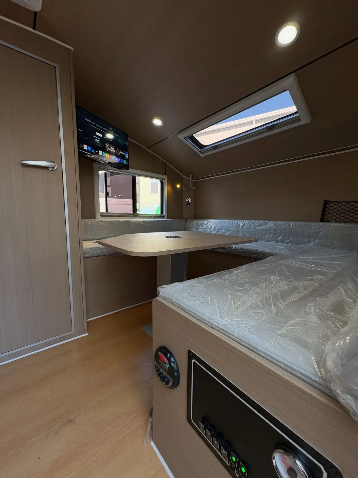 Max timber-finish interior with mattress, raised table and cupboards