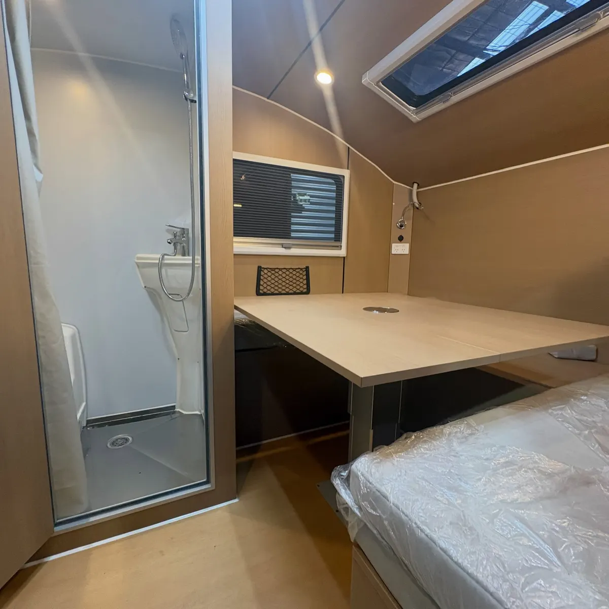 Tamara’s Max interior with dining table, seating, bed and roof window
