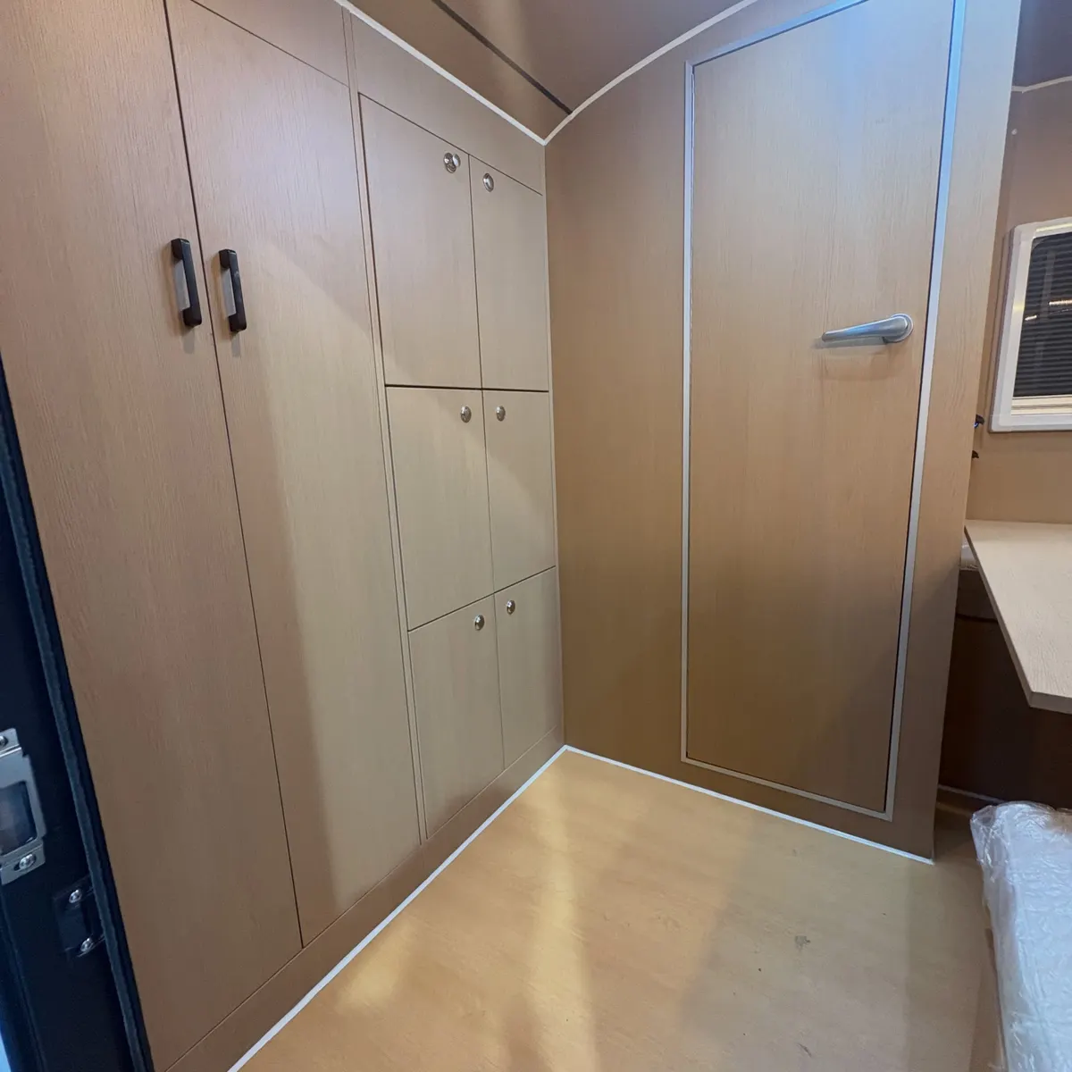 Full-height wardrobe and overhead cupboards inside Tamara’s wood-finish Max
