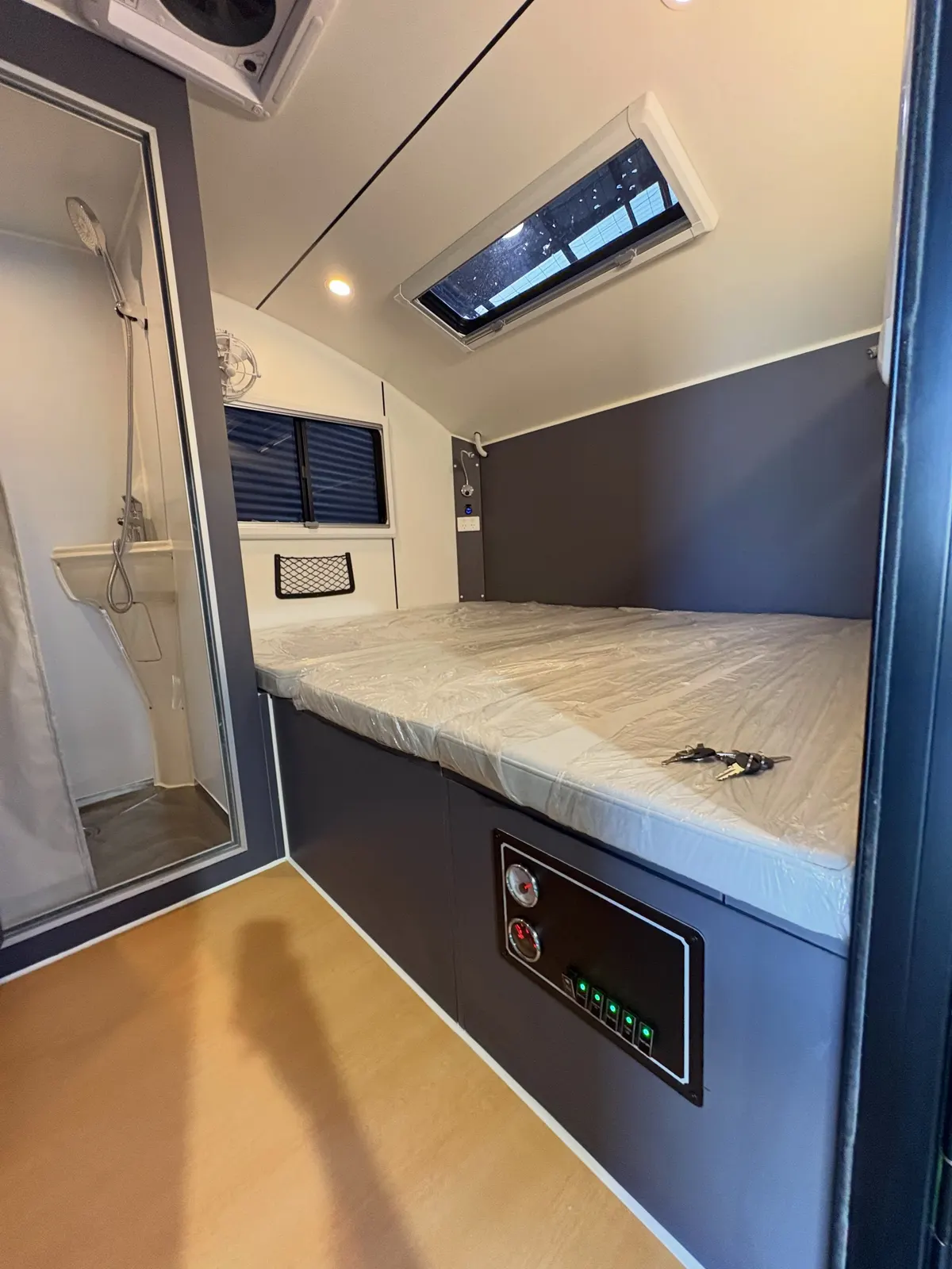 Current Max Off Road sleeping cabin with mattress, grey cabinetry and roof window