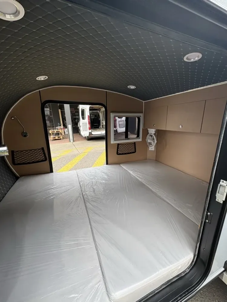 The sleeping cabin, mattress and security mesh doors inside a Breath trailer