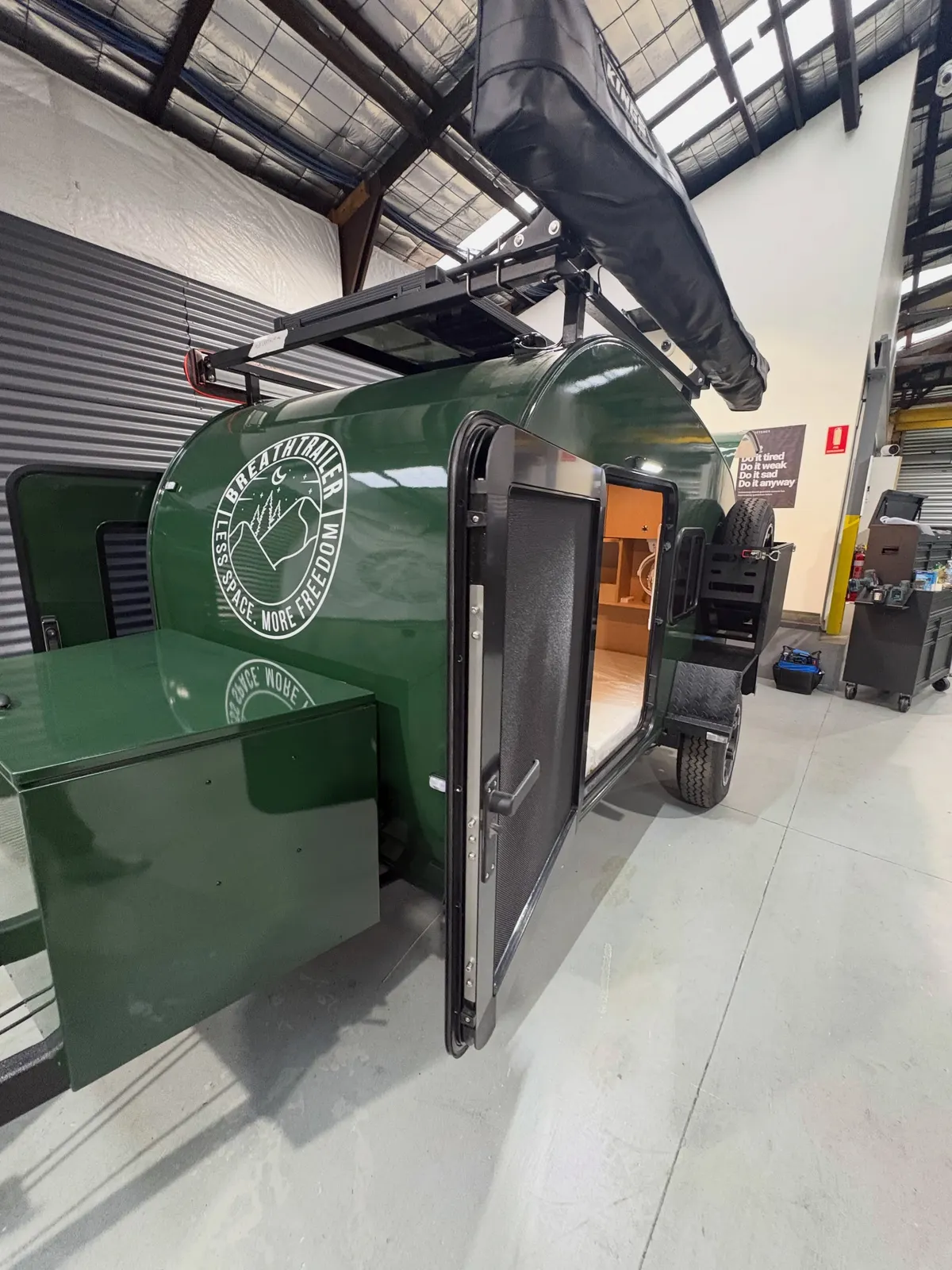 New green Ultra with its side door open, spare tyre and front battery box