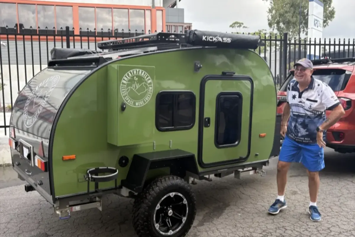 A different Ultra owner standing beside his olive green trailer at collection